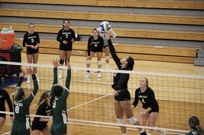 women's volleyball game with player hitting ball in air