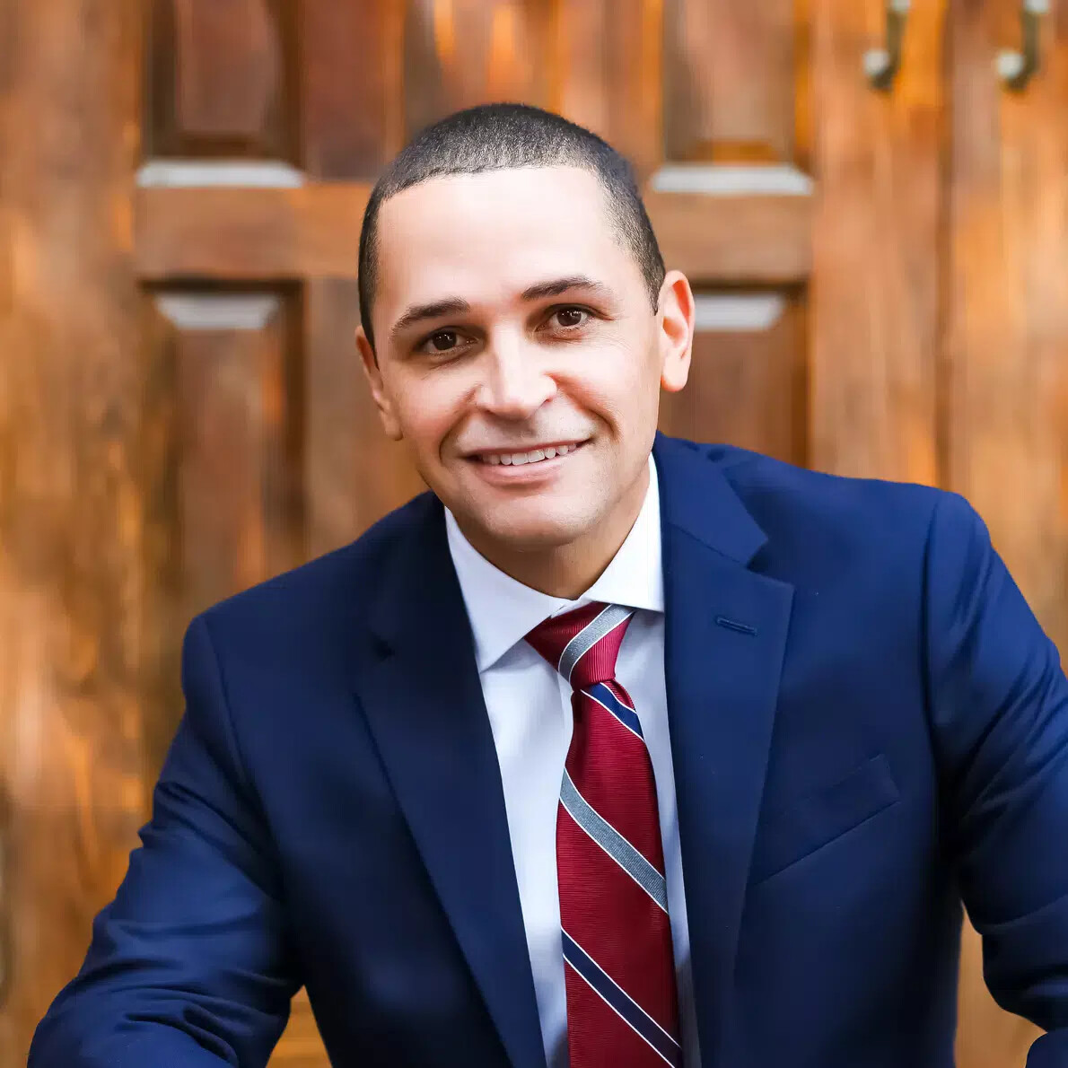 javiar avila in blue suit and red striped tie