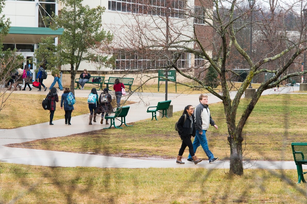 students walking outside with West Building in background