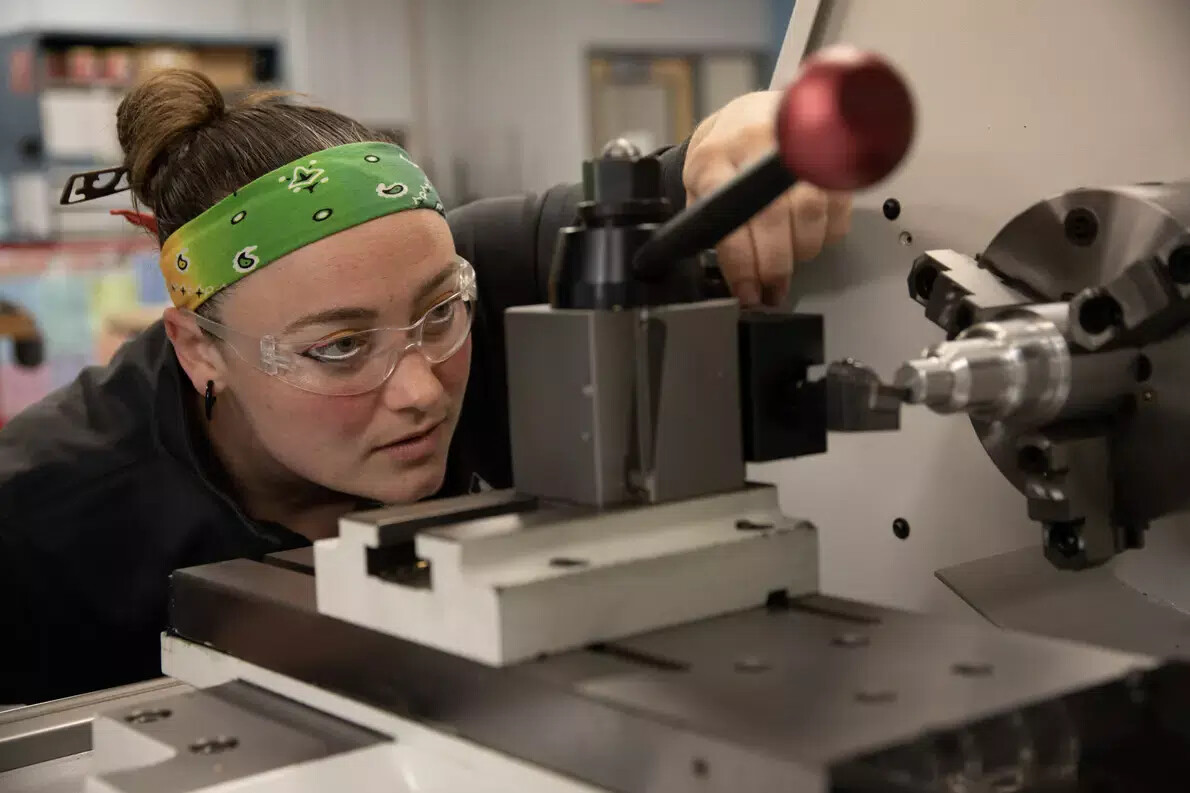 female manufacturing student with green bandana headband