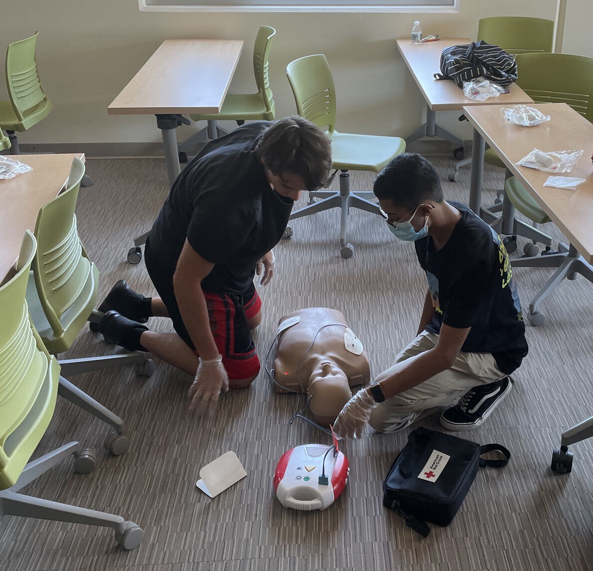2 male students working with dummy on cpr skills