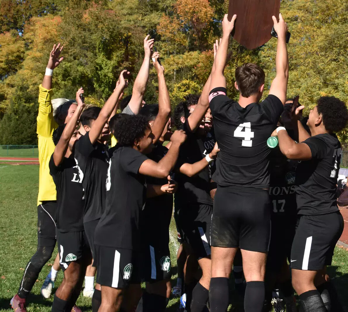 men's soccer players from back with hands in air