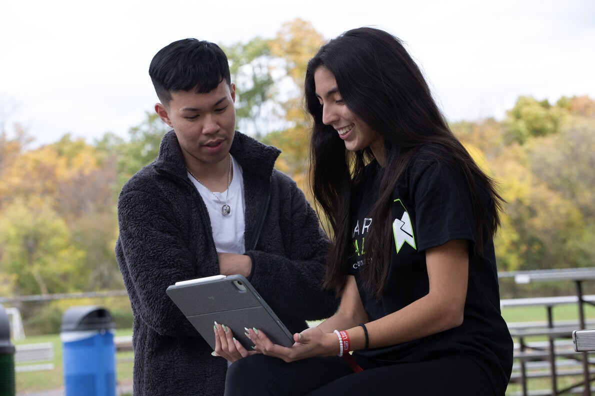 female student with long nails holding laptop with male student