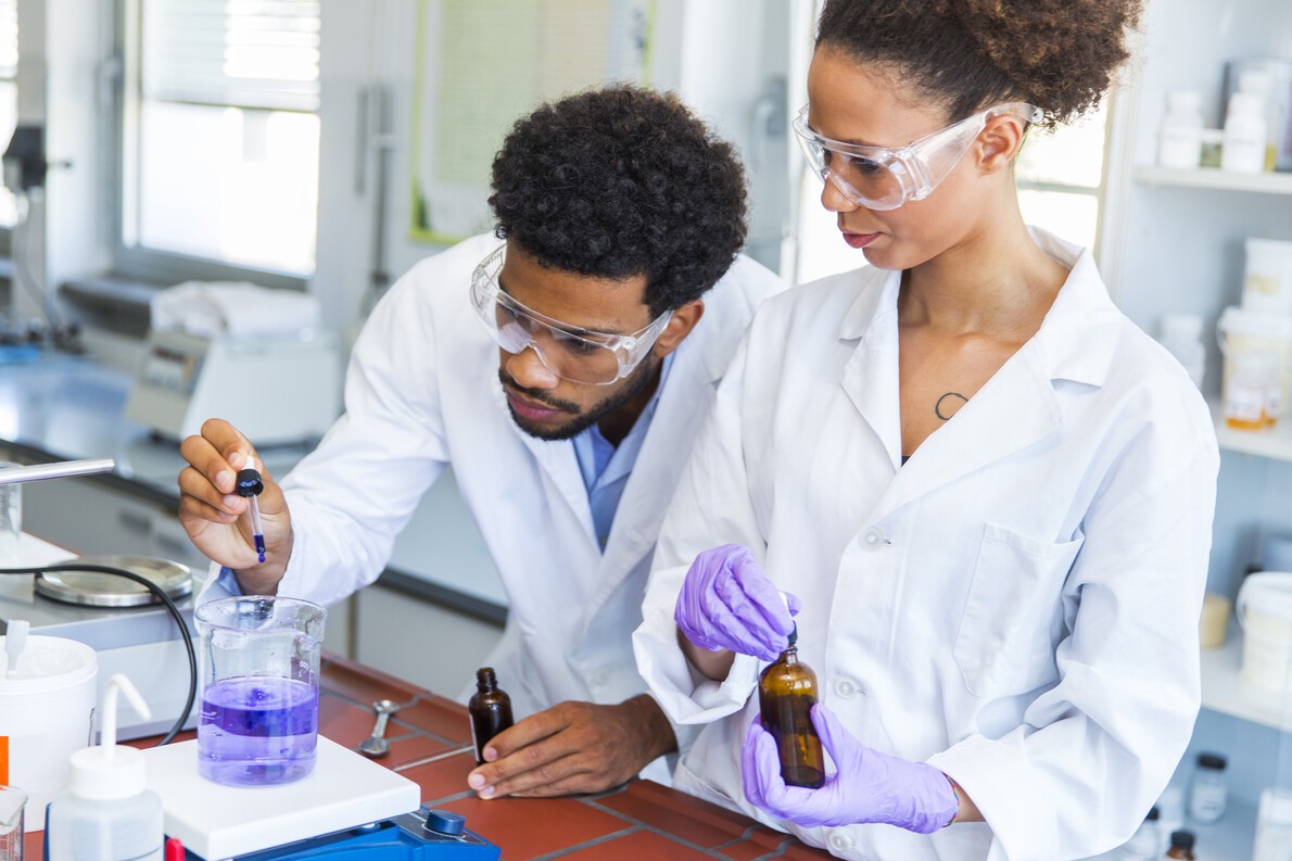 male and female scientists working with blue liquid