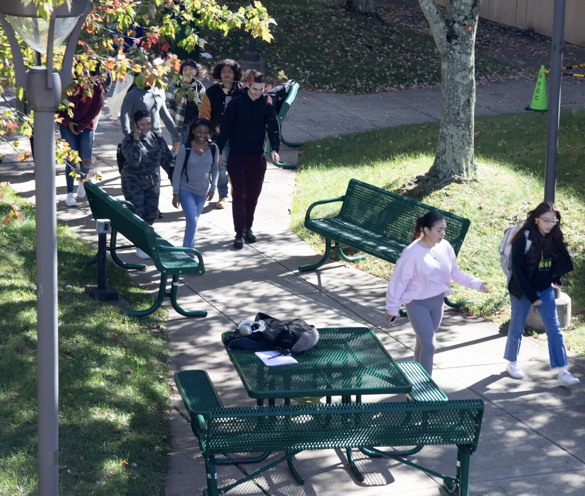 students walking near benches and picnic tables