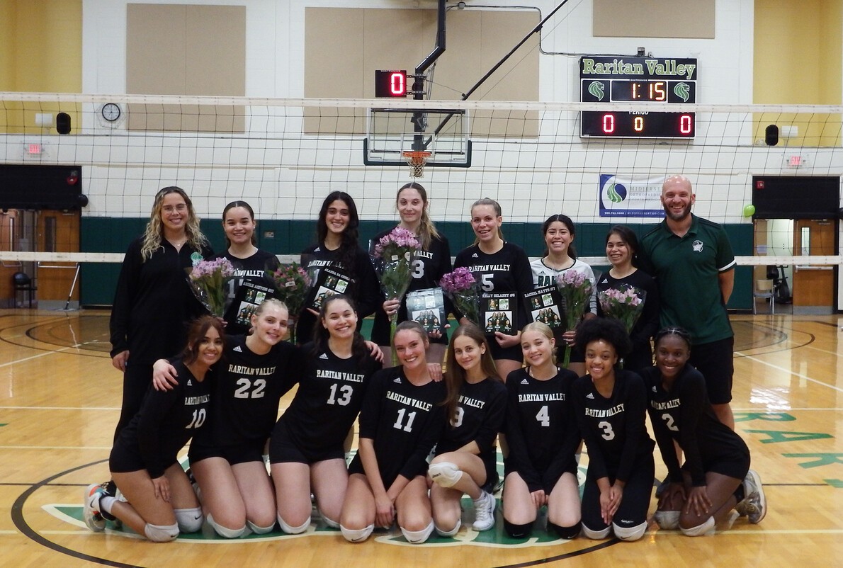 women's volleyball team with coaches and flowers