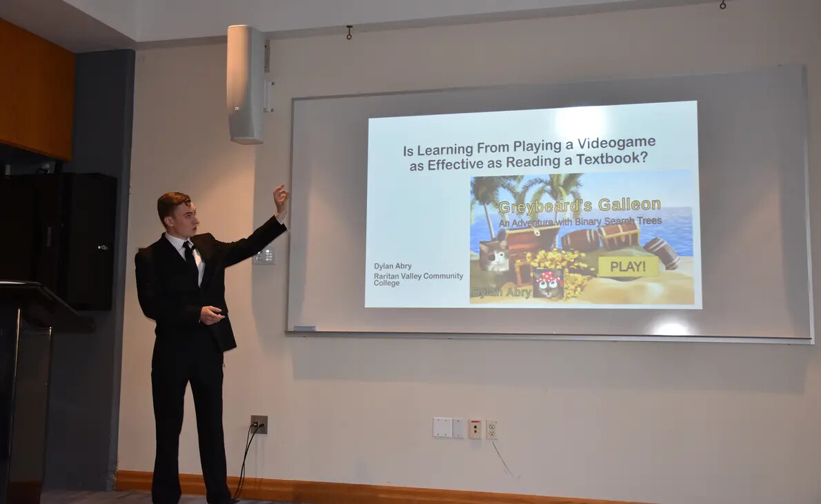cropped pic of male student with slide about videogames