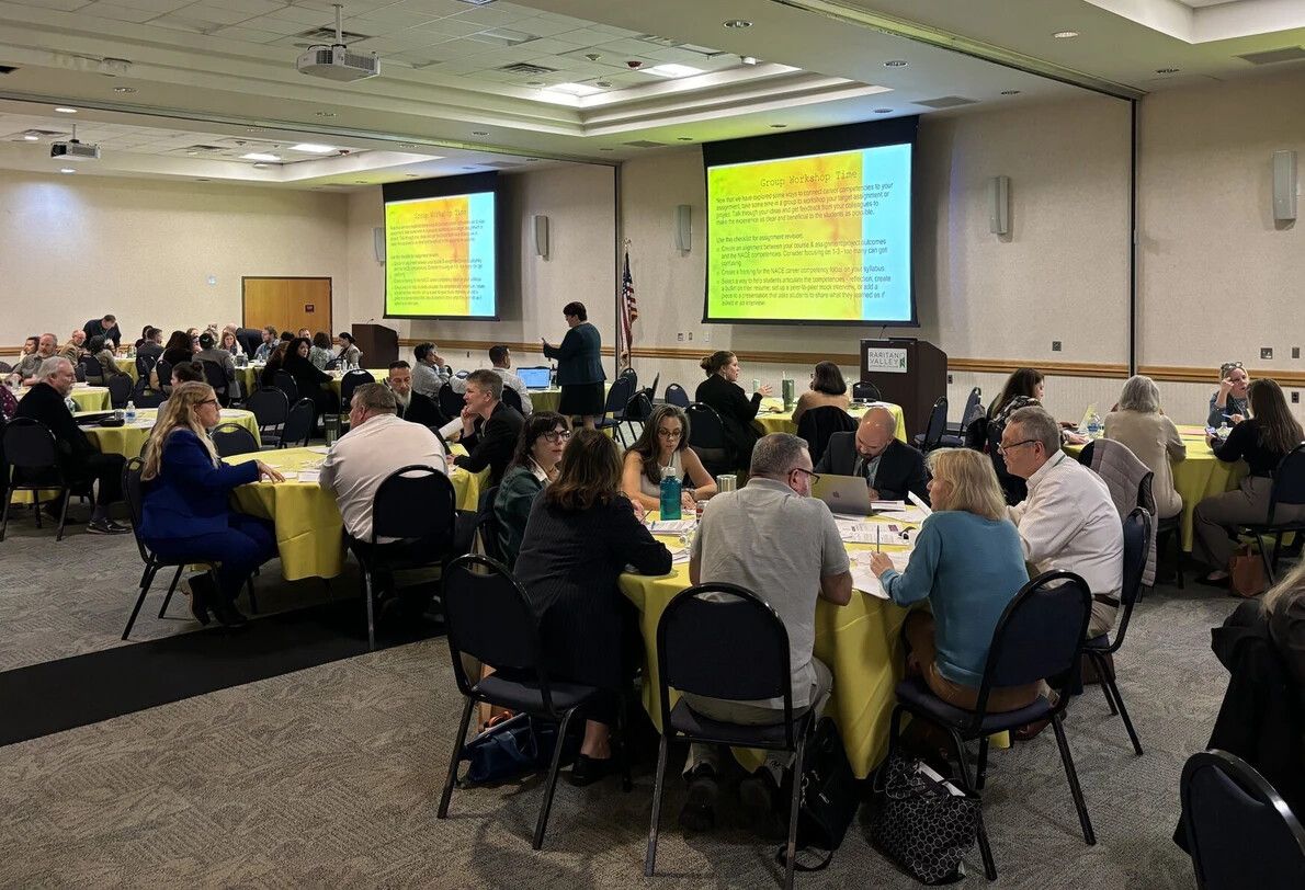 tables of people in conference room with screens