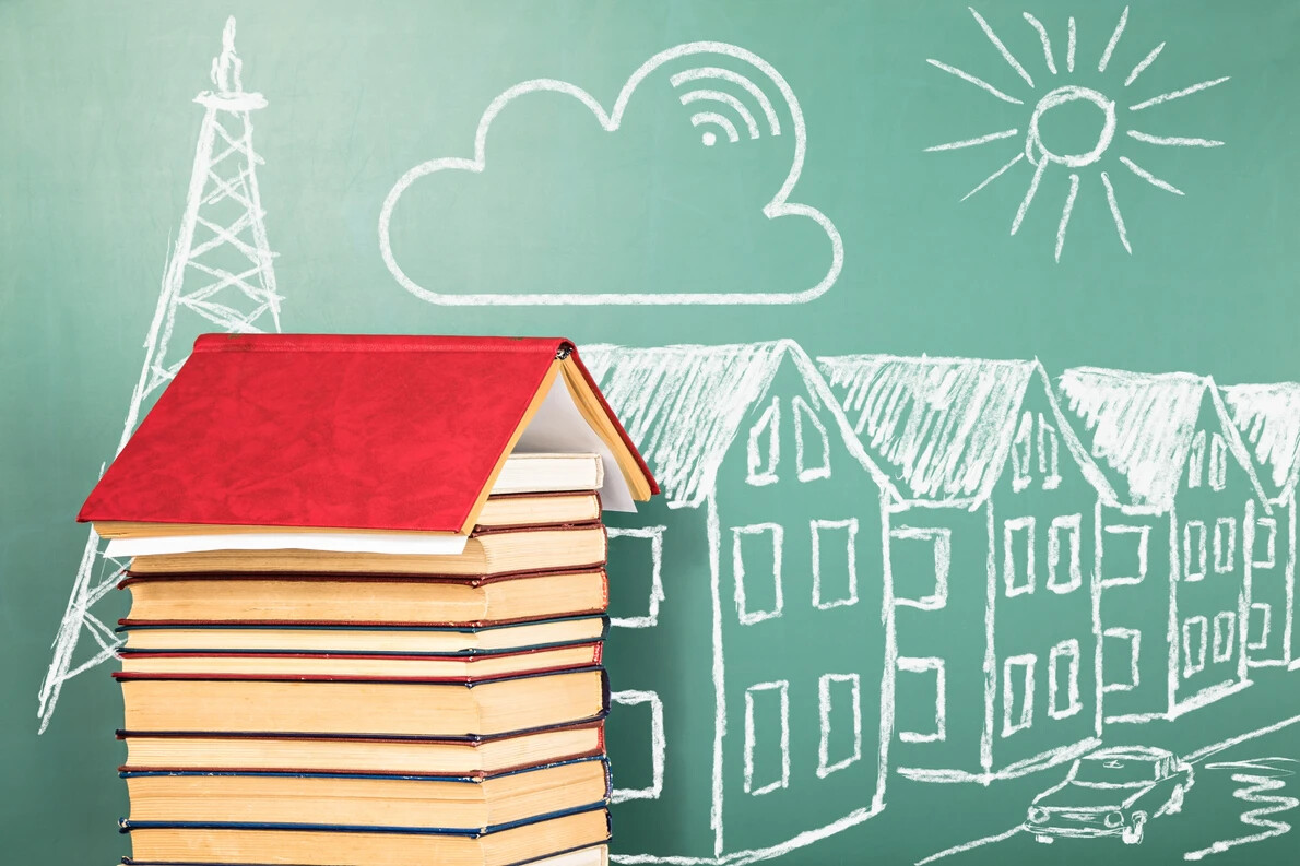 stack of books and chalk drawings of houses