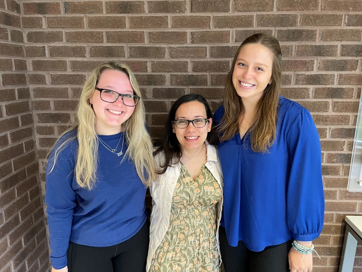 3 females in front of brick wall