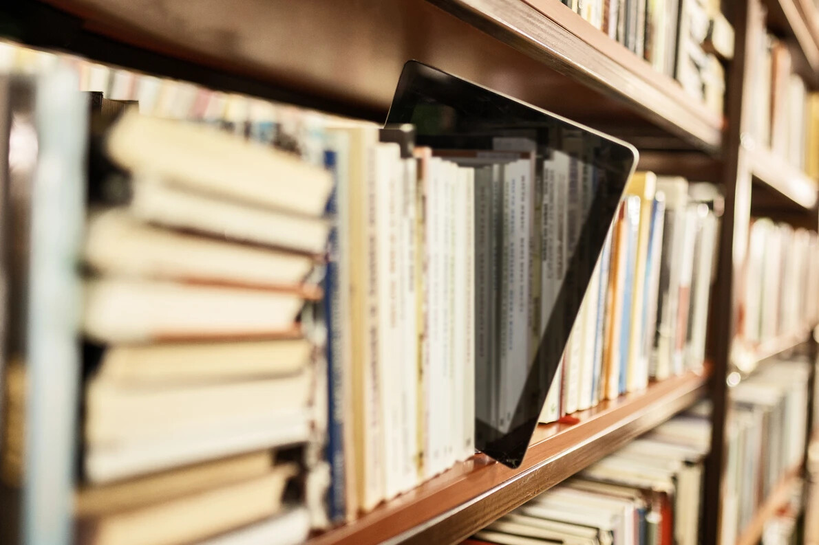 tablet in rows of library books