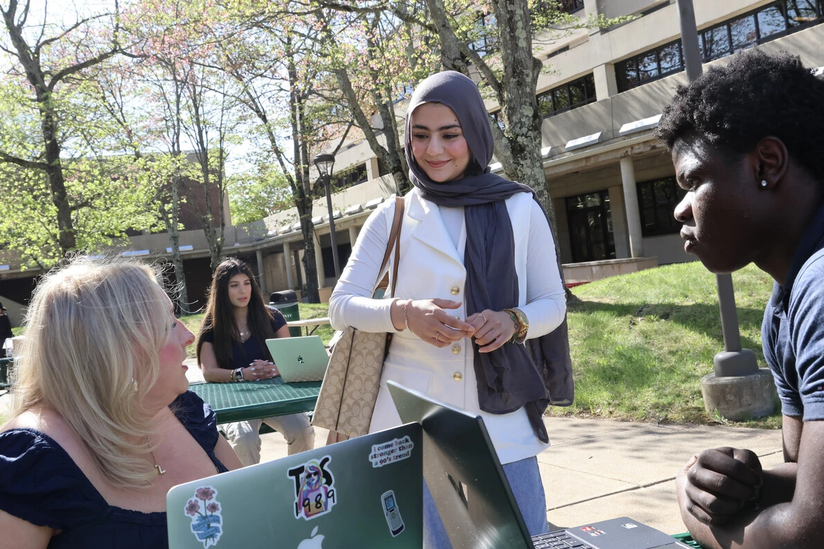 students sitting and standing outside in courtyard