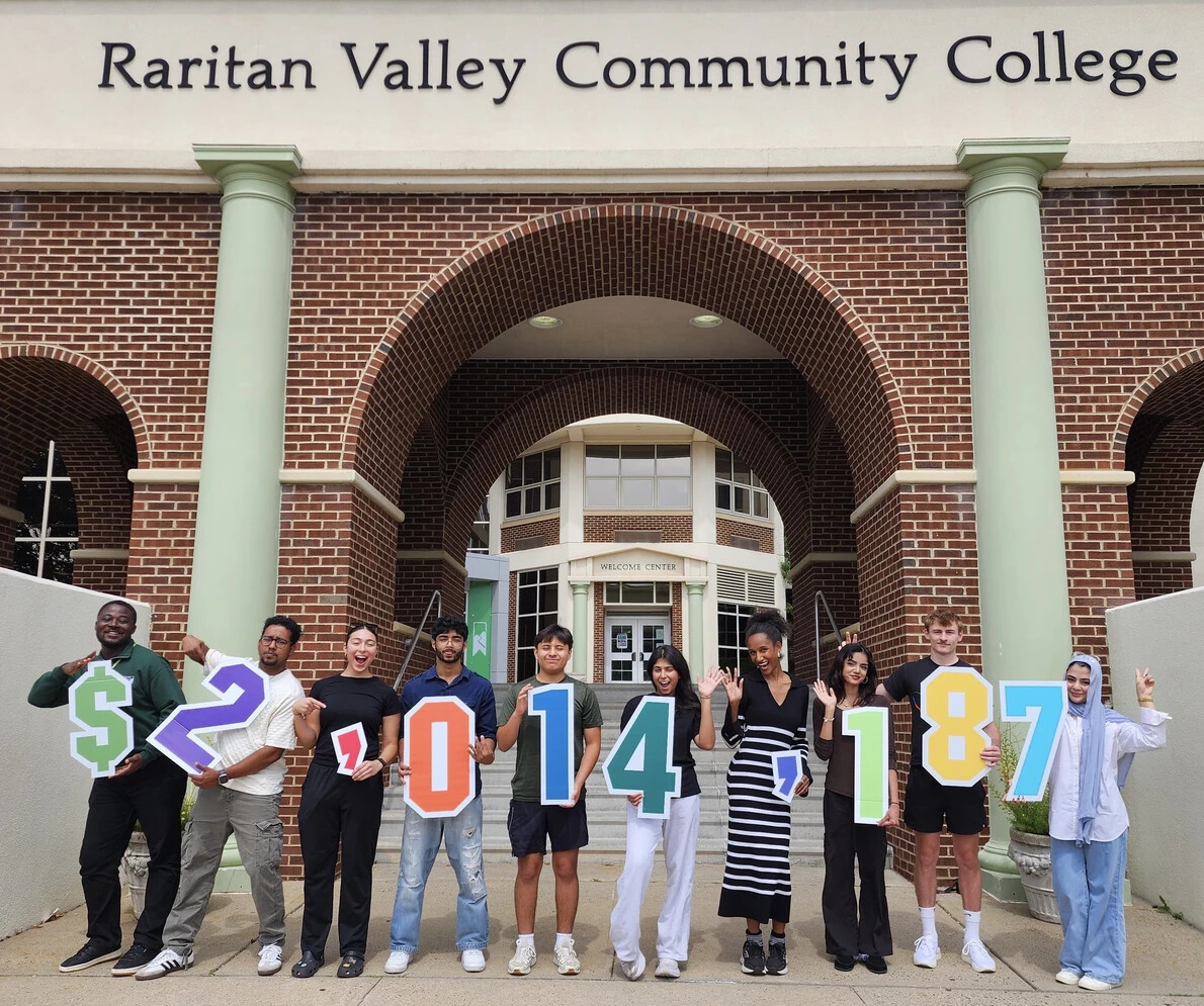students holding numbers in front of arches