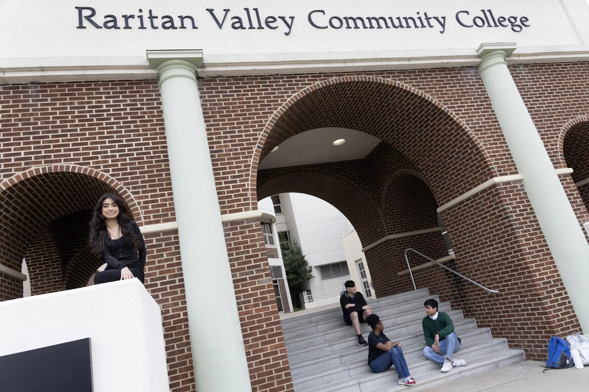 students on front steps sitting under arches