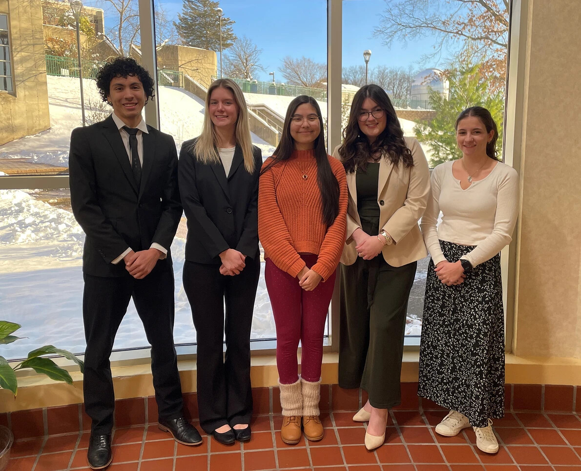 5 honors college students in front of window with snow outside