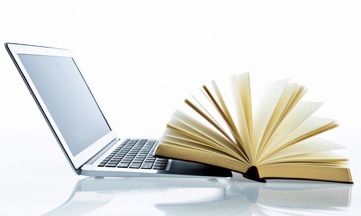 open book next to laptop