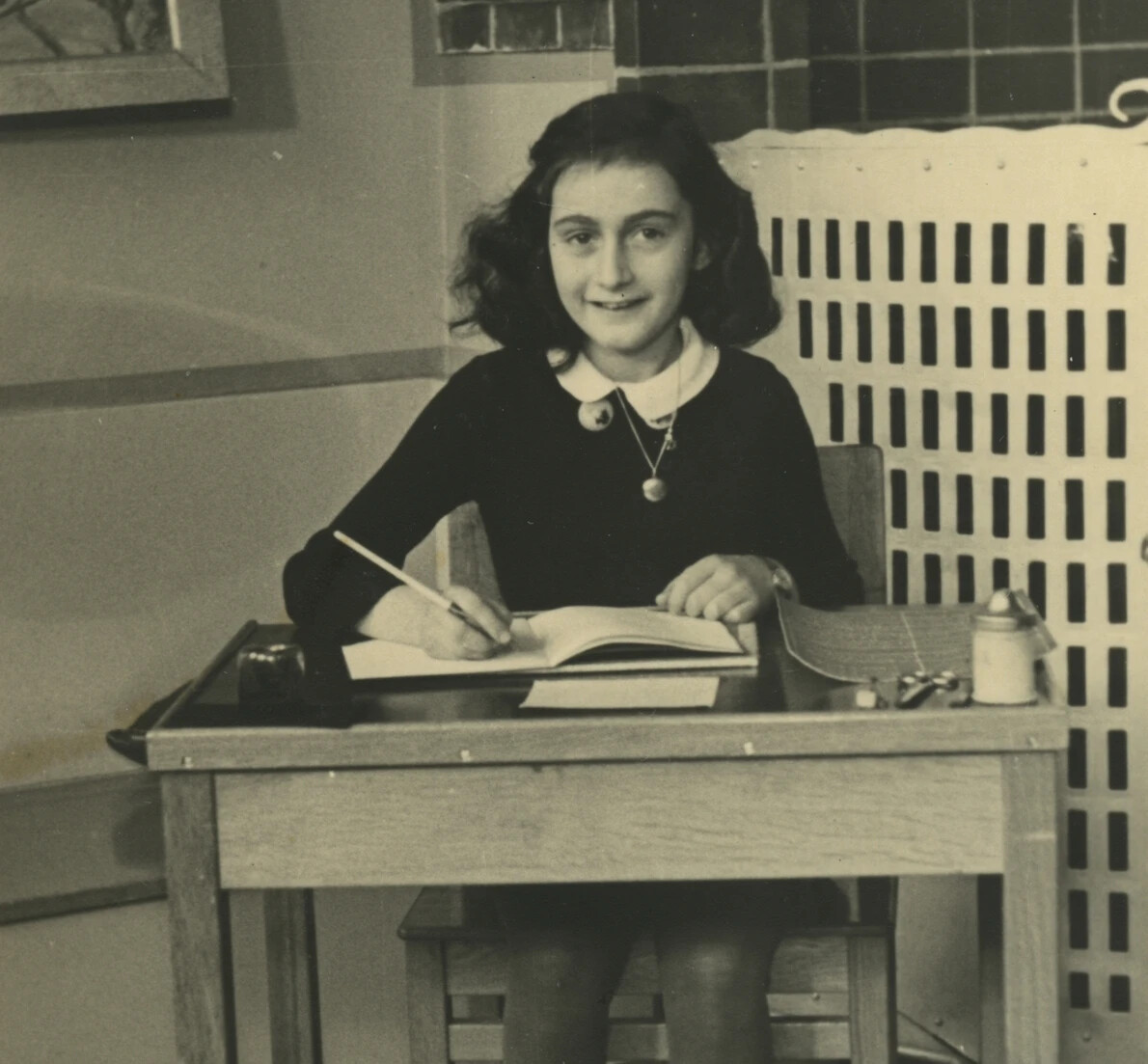 anne frank writing at desk