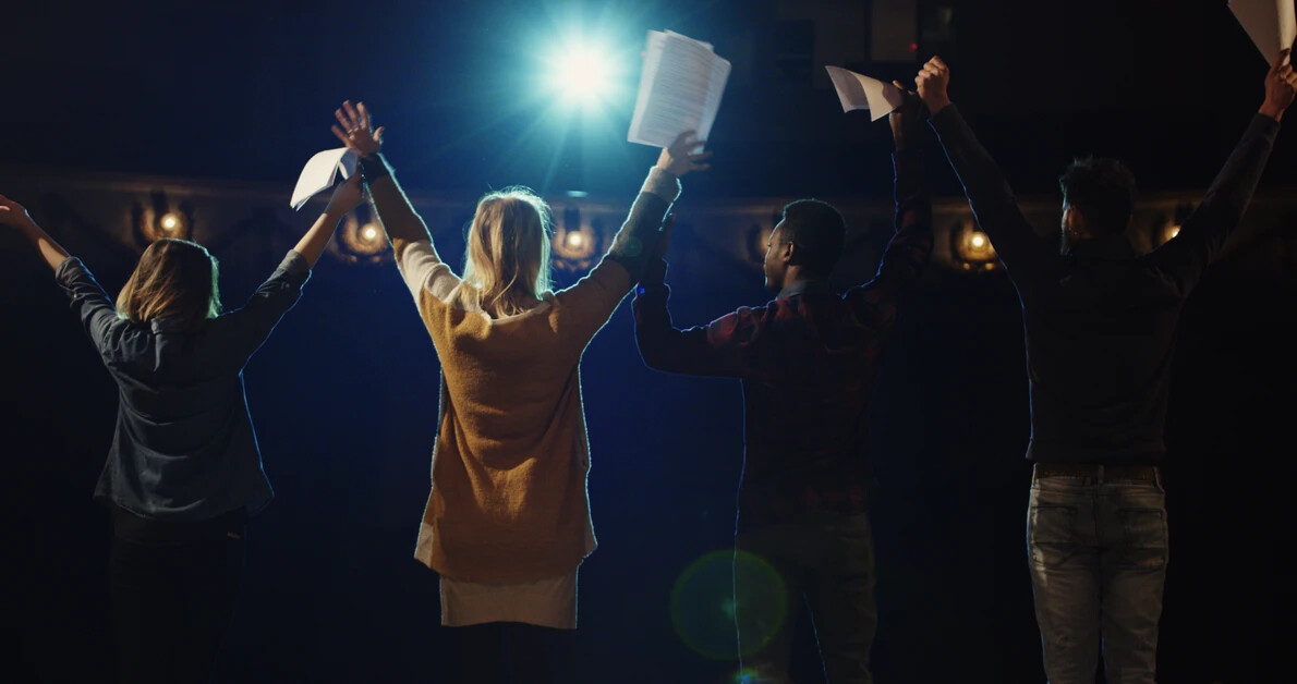 backs of actors bowing on stage