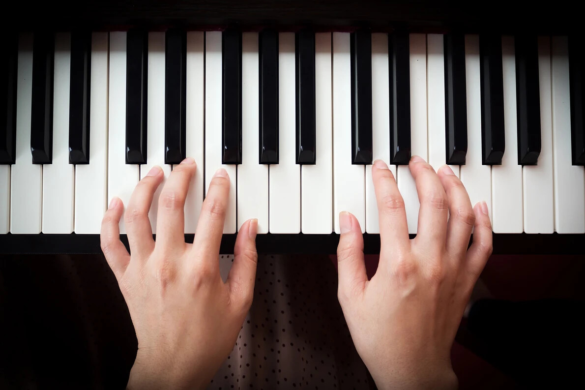 woman's hands on piano
