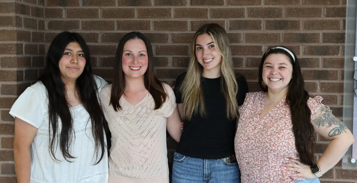 four student in front of brick wall at rvcc