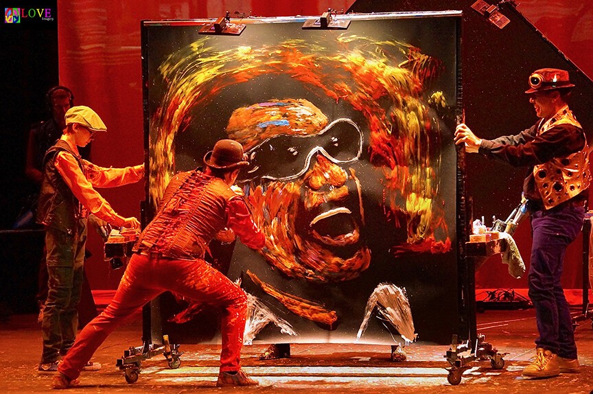 performers painting on a large canvas