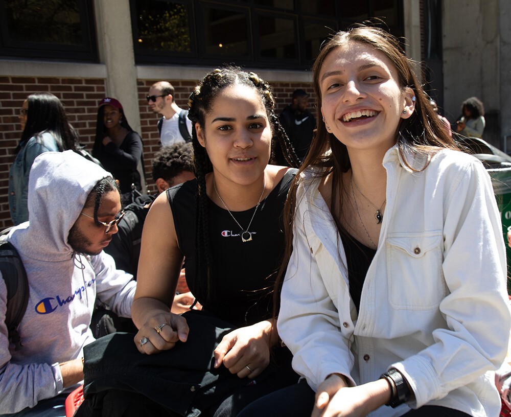 two female students sitting outside college