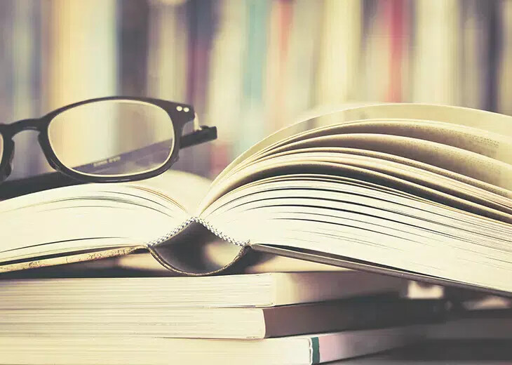 glasses on top of pile of books