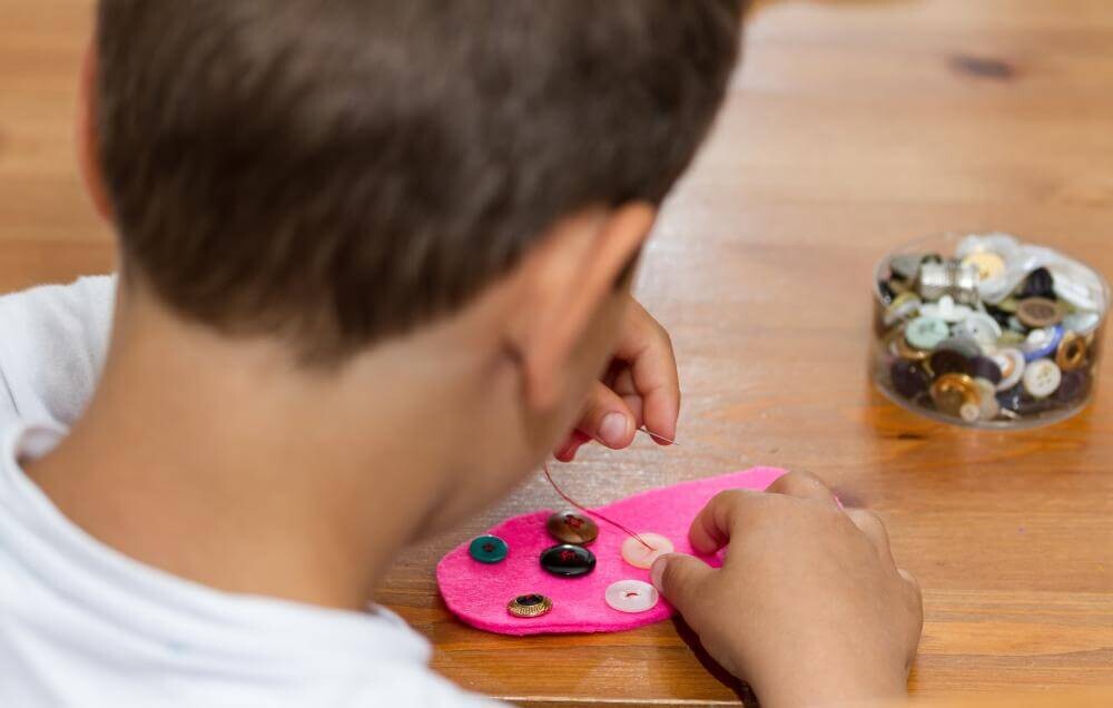 boy sewing buttons