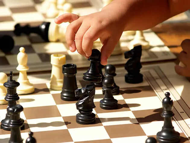 child's hand playing chess