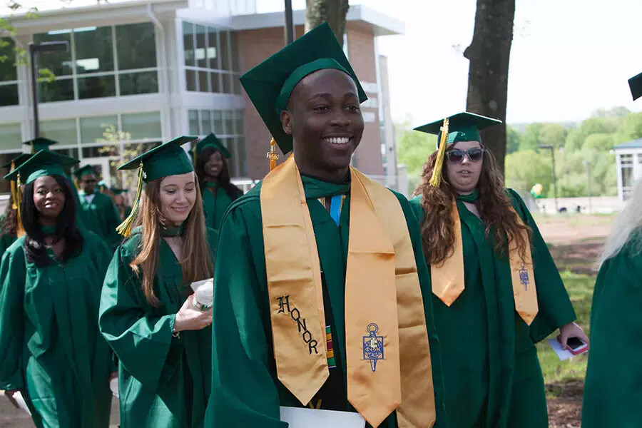 line of grads with one wearing honors stole