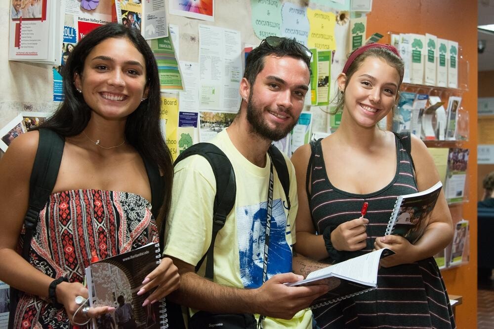 3 students holding student planners