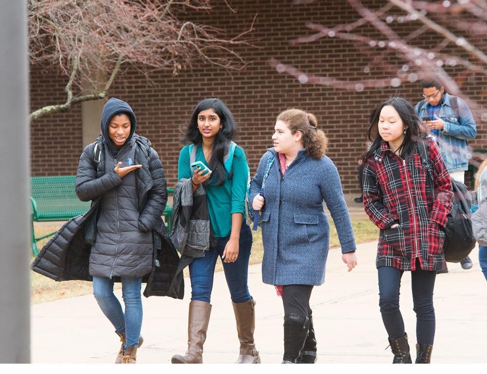 four female students walking outside together