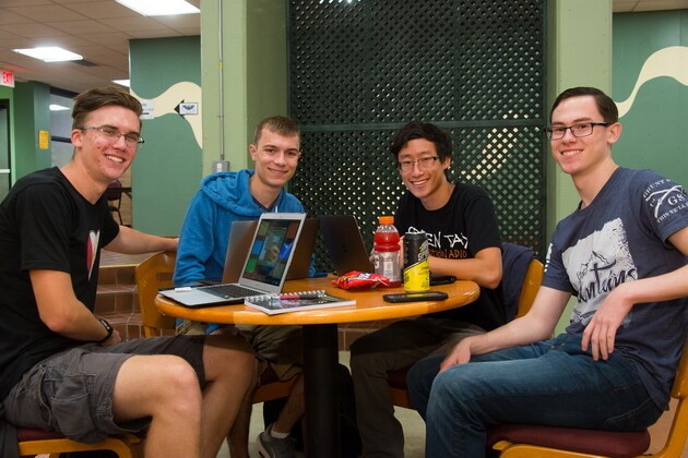 four male students sitting around table