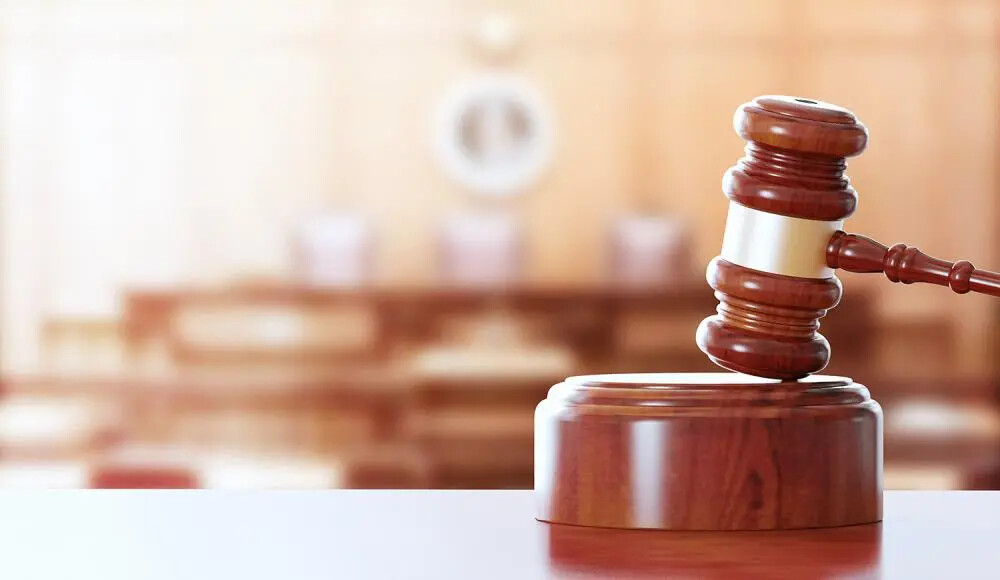hammer in gavel with courtroom dulled in background