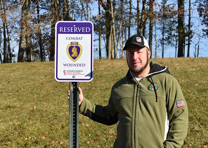 Justin Macarone in front of veteran parking sign