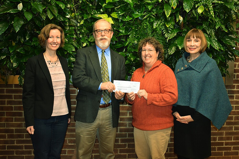 four people with check presentation