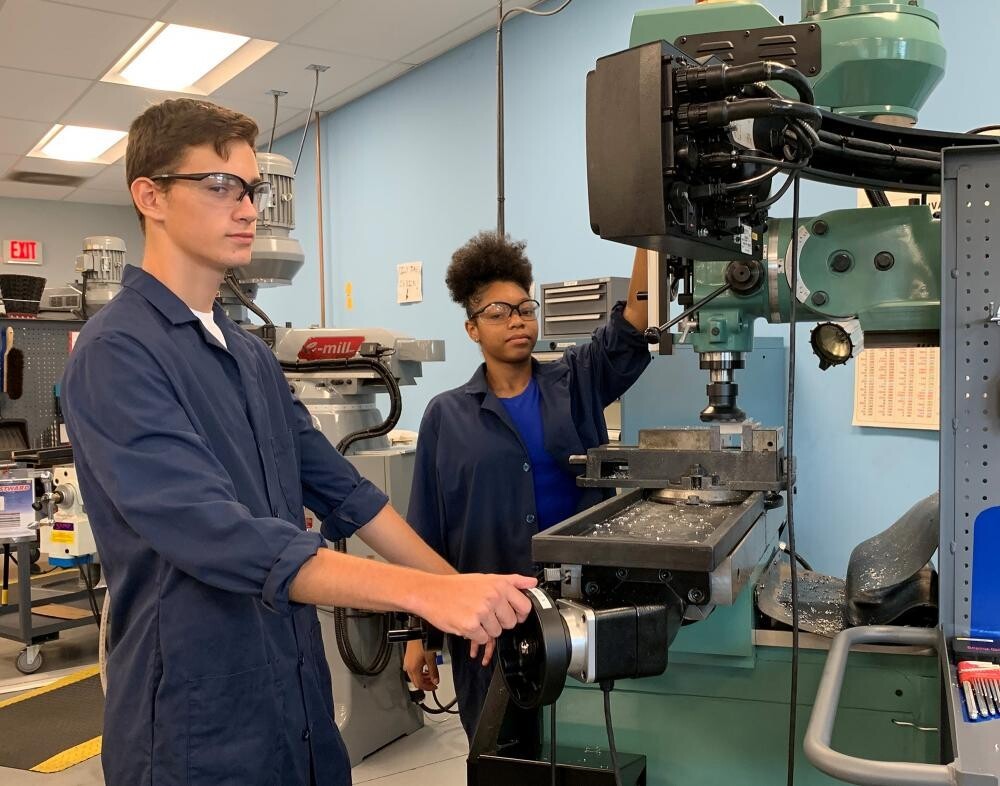male and female hs students on advanced manufacturing machines