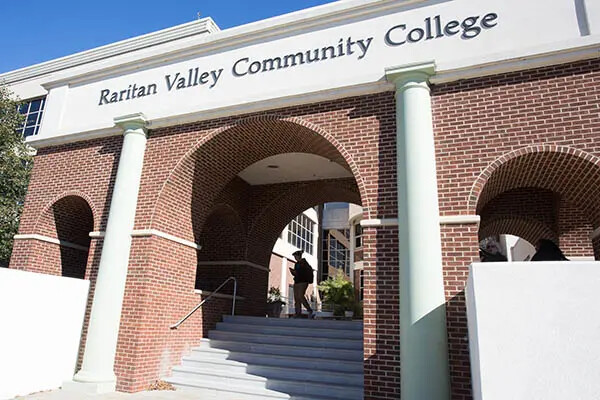 photo of front of college with shadow under arches