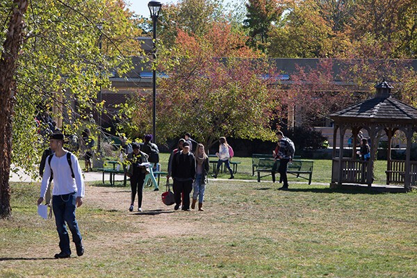 students walking outside with autumn trees