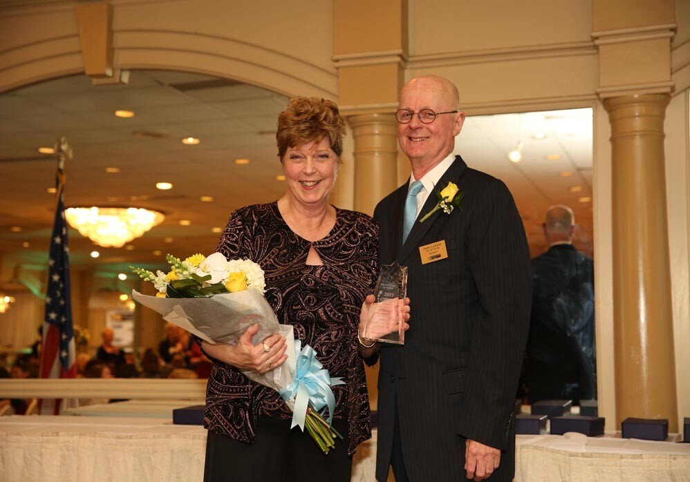 Carol Patterson with award and John Lanier