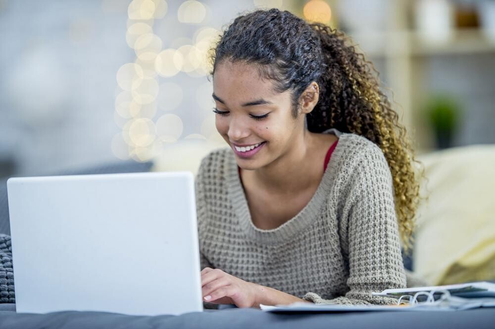 teen girl on laptop with long dark cury hair
