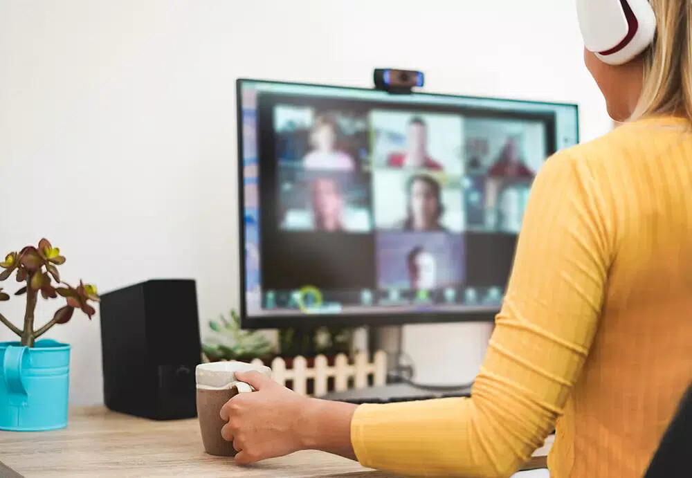 woman in gold shirt on virtual conference