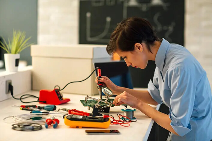 woman soldering circuit board