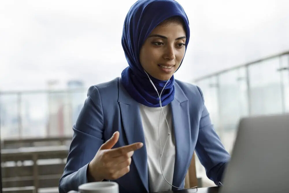 young woman in blue blazer on laptop