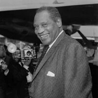 A photo of Paul Robeson smiling for photographers.