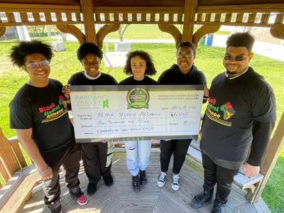 5 students holding large check