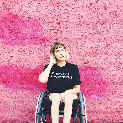 woman in wheelchair with pink background
