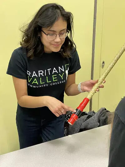 female student holding wooden pole for experiment