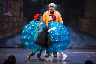 man in yellow jacket and two kids in balloon suits