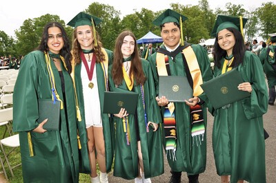 group of grads holding diploma covers